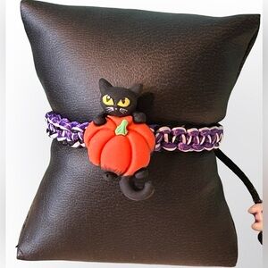 Black cat hanging on pumpkin Halloween adjustable bracelet, black/white/purple